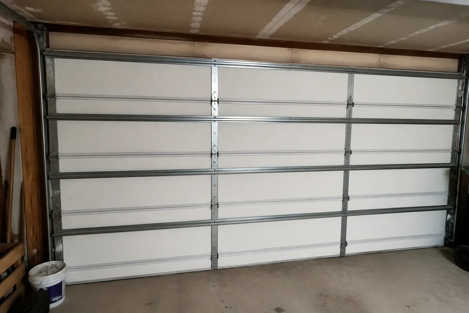 Interior of a closed sectional door with horizontal metal reinforcement struts. — Wind-Rated Garage Door Replacement, New Tecumseth